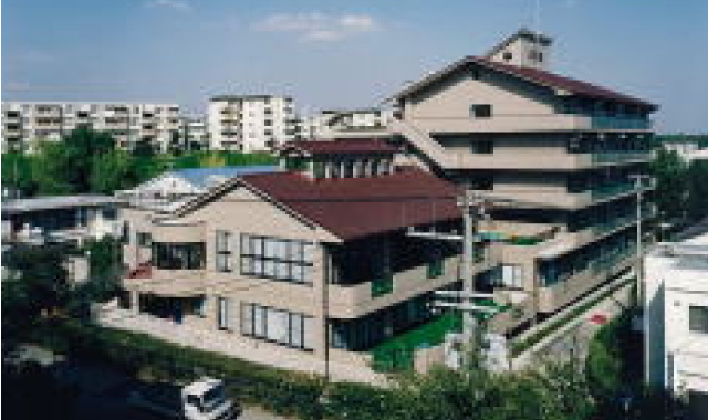 介護施設の建物外観。複数棟の施設が見える晴天時の撮影。